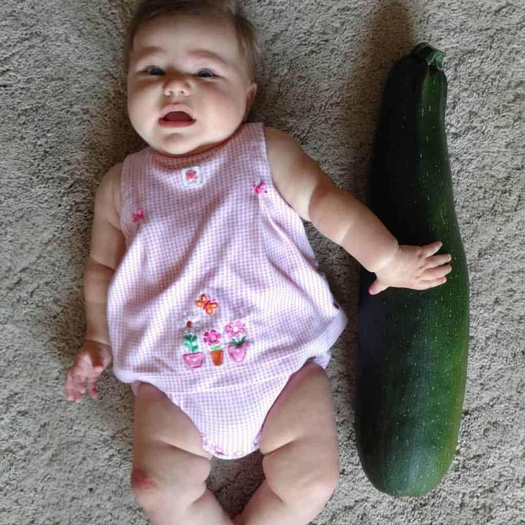 Emma and one of our zucchini's from the garden