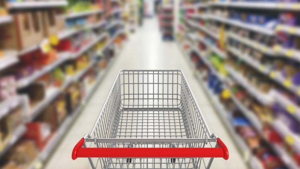 Shopping cart in aisle of grocery store