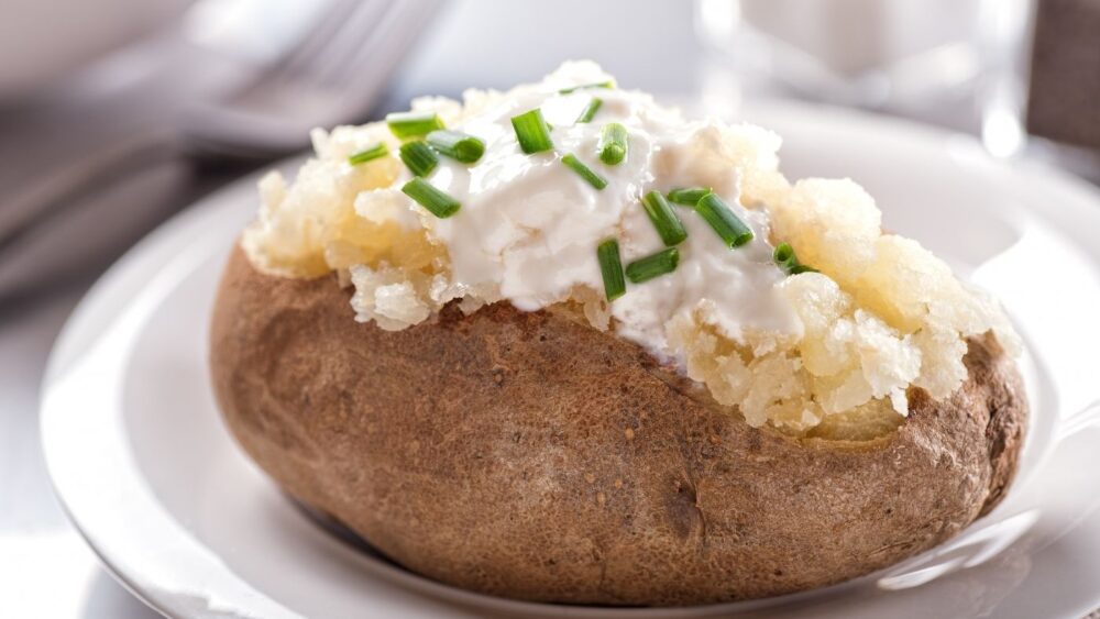 close up baked potato with sour cream